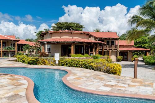a resort with a swimming pool in front of a building at Seascape Villas in San Pedro