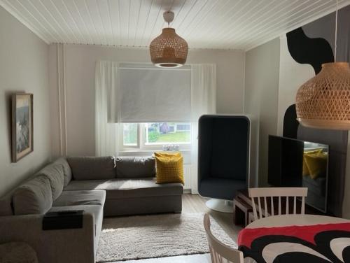 a living room with a couch and a chair at Mukava saunallinen kaksio omalla sisäänkäynnillä ja ilmaisella autopaikalla in Kuopio