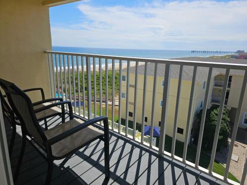 a balcony with two chairs and a view of the beach at Surf Side Hotel in Nags Head