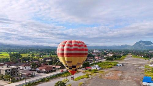 a hot air balloon flying over a city at Vangvieng Sisavang Mountain View Hotel in Vang Vieng