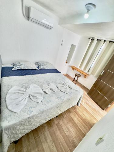 a bedroom with a bed with white sheets at Pousada flor do sertão in Piranhas