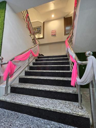 a set of stairs with pink and white curtains at Hotel Royal Mithila Private Limited in Janakpur