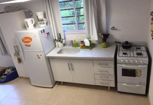 Una cocina con un refrigerador blanco y un fregadero. en mi encanto, en Mar Azul