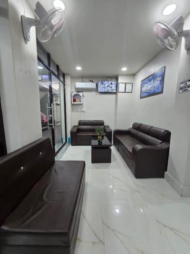 a living room with two leather couches and a tv at Hotel Royal Mithila Private Limited in Janakpur