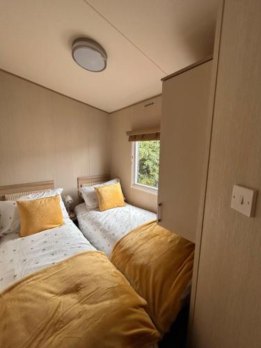 two beds in a small room with a window at Ty hedd static caravan in Caernarfon