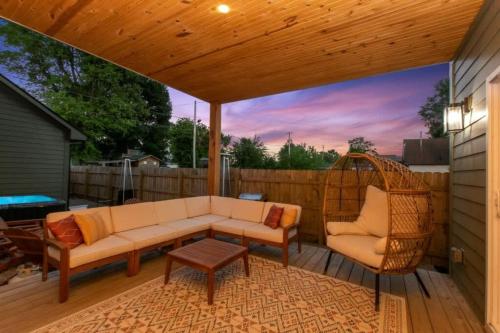 a patio with a couch and chairs on a deck at Newly Renovated l Fire Pit Hot Tub Arcade in Indianapolis