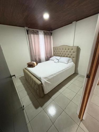 Un dormitorio con una cama grande en una habitación. en Alojamiento Tranquilo Occidente, en San Ramón