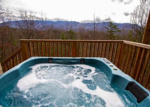 a hot tub on a deck with snow on it at Pinnacle Panorama by American Patriot Getaways in Rocky Grove