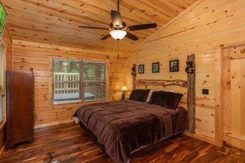 a bedroom with a bed and a ceiling fan at Paws on the Porch by American Patriot Getaways in Glade