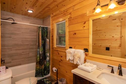 a log cabin bathroom with a sink and a toilet at Paws on the Porch by American Patriot Getaways in Glade