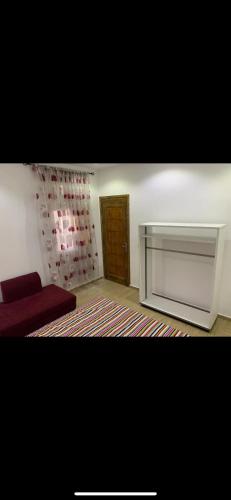 a living room with a red couch and a door at Layan's Seaside Haven in Banzart