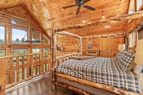 a log cabin bedroom with a bed and a ceiling fan at Peaceful Feeling by American Patriot Getaways in Seaton Spring