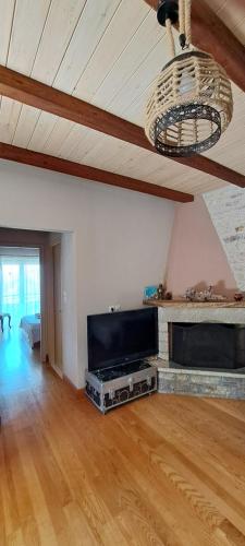 a living room with a flat screen tv and a ceiling at Sunset in Rodhiná