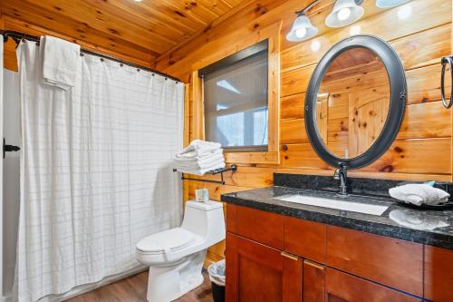 a bathroom with a toilet and a sink and a mirror at Peaceful Feeling by American Patriot Getaways in Seaton Spring