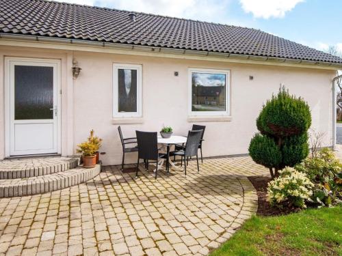a patio with a table and chairs in front of a house at 4 person holiday home in Toftlund in Toftlund