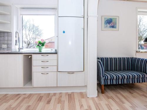 a kitchen with a refrigerator and a chair at 4 person holiday home in Toftlund in Toftlund