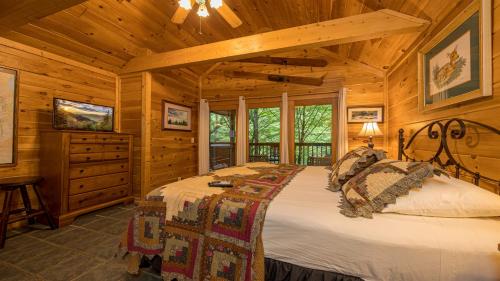 Un dormitorio con una cama grande en una cabaña. en Rivers Edge by American Patriot Getaways, en Pittman Center