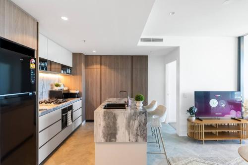 a kitchen with a island in the middle of a room at Queen's Wharf Lv 51 - 2Bedroom Skybound Sanctuary on Casino in Brisbane
