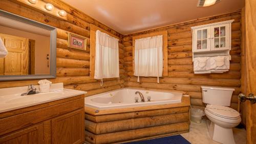 ein Badezimmer mit Badewanne, Toilette und Waschbecken in der Unterkunft Sierras Mountain Retreat by American Patriot Getaways in Line Spring