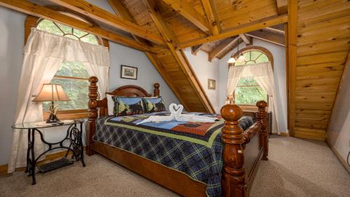 ein Schlafzimmer mit einem Bett und einem Tisch und zwei Fenstern in der Unterkunft Sierras Mountain Retreat by American Patriot Getaways in Line Spring