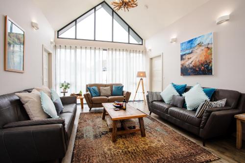 a living room with two couches and a table at Cowslip in Bamburgh