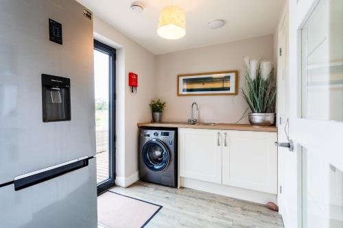 a laundry room with a washer and dryer at Cowslip in Bamburgh