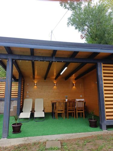 a wooden pergola with a table and chairs at COLȚ DE RAI - A Frame in Corbi