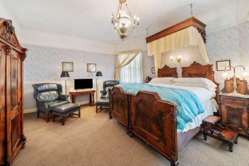 a bedroom with a bed and a desk and a chair at Brinnwood Bed & Breakfast in Sutter Creek