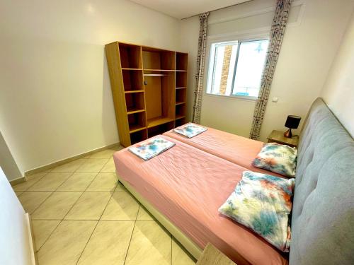 a bedroom with a bed with two pillows on it at Apartamentos Al Borj 1B إقامة البرج in Ifargane