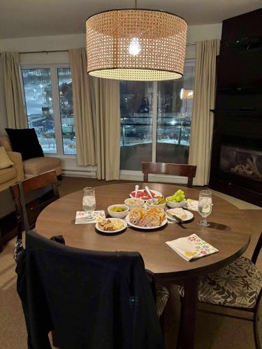 a dining room table with plates of food on it at Superbe ski-in ski-out condo in Bromont