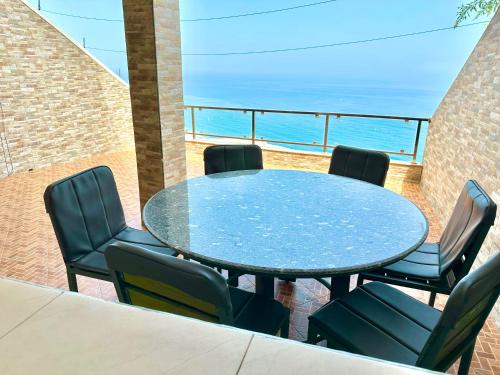 a table and chairs with the ocean in the background at Apartamentos Al Borj 1B إقامة البرج in Ifargane