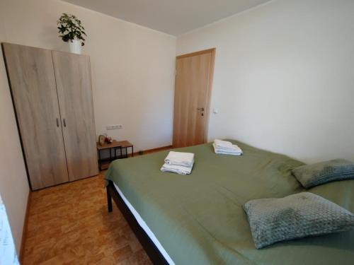 a bedroom with a green bed with towels on it at Ferienwohnung Regau 