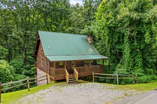 a cabin in the woods with a green roof at Smoky Bears Creek by American Patriot Getaways in Line Spring