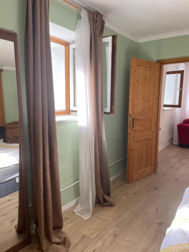a bedroom with curtains and a window and a door at NatureStay in Straßberg