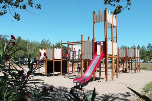- une aire de jeux avec toboggan dans le sable dans l'établissement Camping Vias-Plage, à Vias