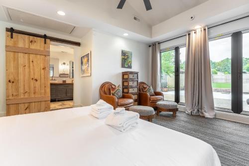 een slaapkamer met een groot wit bed en stoelen bij Riverside Bungalow in Nashville