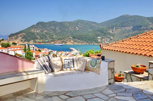 a couch on a balcony with a view of the water at Aperanto Galazio in Skopelos Town