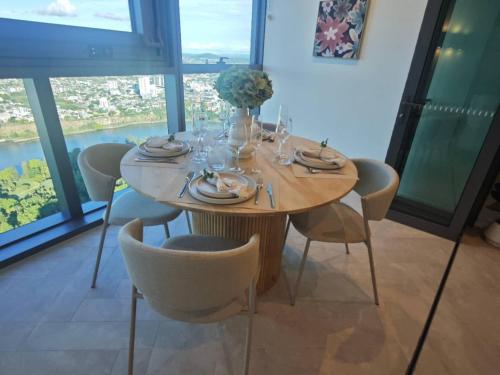 a dining room table with chairs and a large window at Highgarden Whispers - Skyhigh Apt on the Star in Brisbane