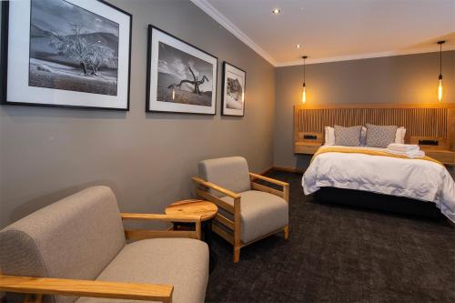 a hotel room with a bed and a chair at Haisley Hotel in Hilton