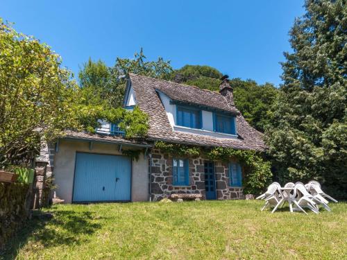 a house with two lawn chairs in front of it at Vic-sur-Cère Family Nest in Vic-sur-Cère
