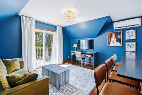 a living room with blue walls and a table and chairs at Estello Suites & Spa in Lac-Mégantic