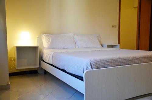 a bed with white sheets and pillows in a room at Casa Alfieri in Paestum
