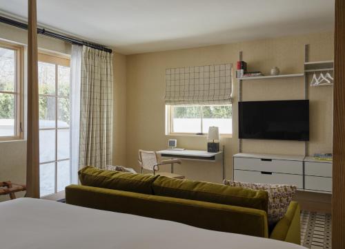 a hotel room with a couch and a desk and a tv at Belden House & Mews in Litchfield