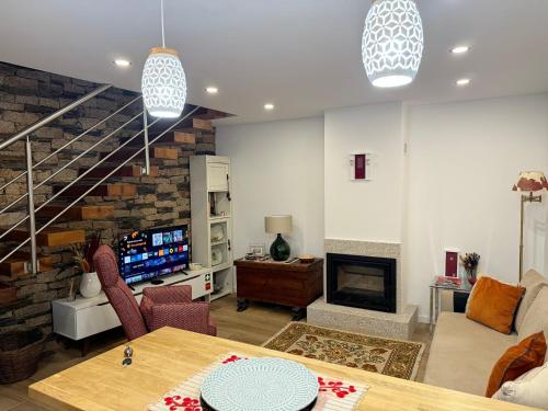 a living room with a couch and a fireplace at Casas do Abô Fredo in Sendim