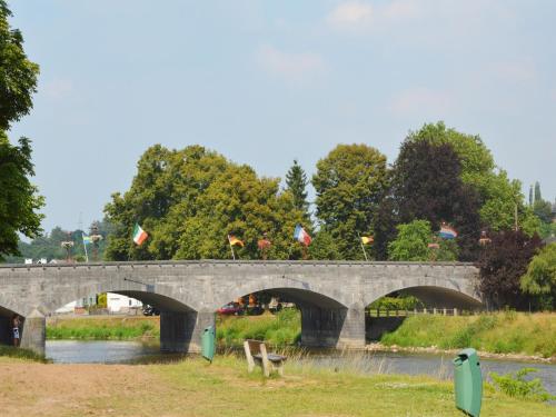 a stone bridge over a river with flags at Spacious Place in Hamoir in Hamoir