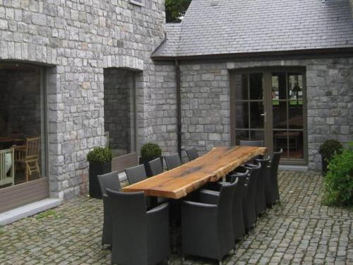 a wooden table and chairs in front of a building at Spacious Place in Hamoir in Hamoir