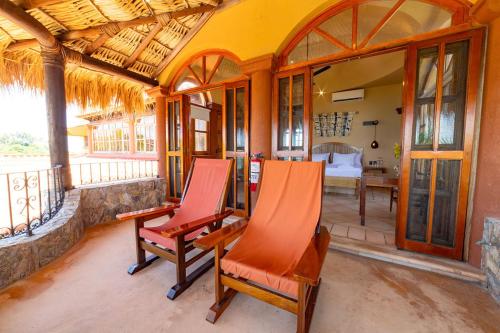 a room with two chairs and a bedroom at Casa Ceiba Huatulco - Adults Only in Santa Cruz Huatulco