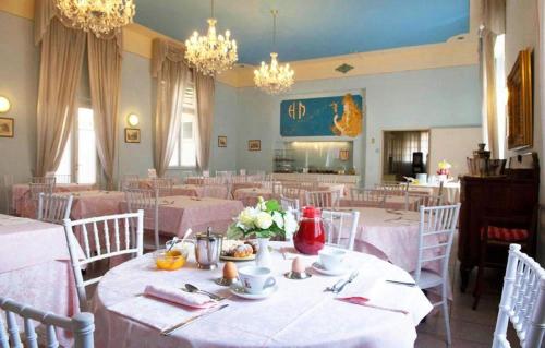 a dining room with white tables and white chairs at Viareggio live in Top deco in Viareggio