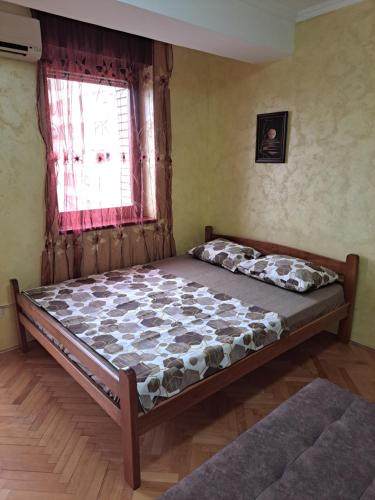 ポドゴリツァにあるSunrise 2の窓のある部屋にある大きなベッド