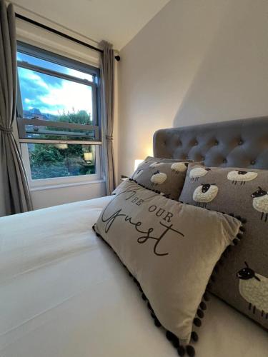 a bed with a pillow with the words our friend written on it at Stylish City Retreat with Views & Court Yard in Leeds